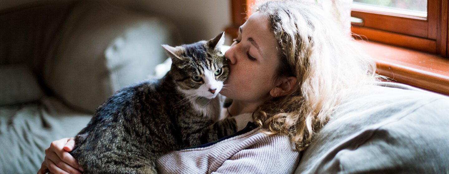 Naine suudleb kassi põsele